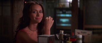 Movie still from “Heartbreakers” (2001), directed by David Mirkin – A woman sitting at a table in front of a bottle of wine; Close Up shot, Over the shoulder angle