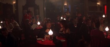 Movie still from “Heartbreakers” (2001), directed by David Mirkin – A man and a woman sitting at a table with a lit candle; Medium shot, High angle