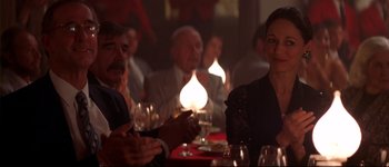 Movie still from “Heartbreakers” (2001), directed by David Mirkin – A group of people sitting around a table with wine glasses; Medium shot, Over the shoulder angle