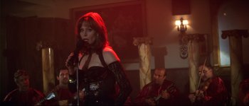 Movie still from “Heartbreakers” (2001), directed by David Mirkin – A woman in a black dress singing into a microphone; Medium shot, Over the shoulder angle