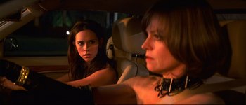 Movie still from “Heartbreakers” (2001), directed by David Mirkin – A woman sitting in the back of a car next to another woman; Close Up shot, Over the shoulder angle