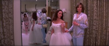 Movie still from “Heartbreakers” (2001), directed by David Mirkin – A woman in a wedding dress standing in front of a mirror; Medium shot, Over the shoulder angle