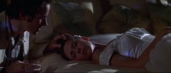 Movie still from “Heartbreakers” (2001), directed by David Mirkin – A woman laying on a bed with her eyes closed; Close Up shot, High angle