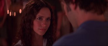 Movie still from “Heartbreakers” (2001), directed by David Mirkin – A young woman looking at the camera while a man looks at her; Close Up shot, Over the shoulder angle