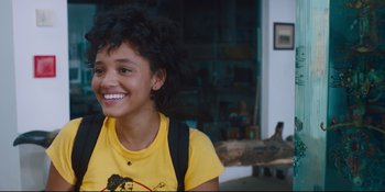 Movie still from “Hearts Beat Loud” (2018), directed by Brett Haley – A young woman smiles brightly while wearing a yellow shirt; Close Up shot, Over the shoulder angle