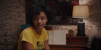 Movie still from “Hearts Beat Loud” (2018), directed by Brett Haley – A young woman sitting in a room with a lamp; Medium shot, Over the shoulder angle