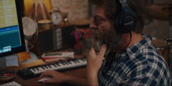Movie still from “Hearts Beat Loud” (2018), directed by Brett Haley – A man with a beard wearing headphones and playing a keyboard; Close Up shot, High angle