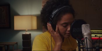 Movie still from “Hearts Beat Loud” (2018), directed by Brett Haley – A young woman wearing headphones is listening to music; Close Up shot, Low angle