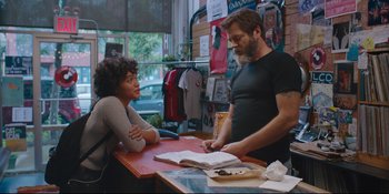 Movie still from “Hearts Beat Loud” (2018), directed by Brett Haley – A man and a woman sitting at a table in front of a book; Medium shot, Over the shoulder angle