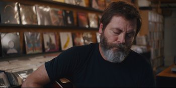 Movie still from “Hearts Beat Loud” (2018), directed by Brett Haley – A man with a gray beard is playing a guitar; Close Up shot, Over the shoulder angle