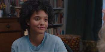 Movie still from “Hearts Beat Loud” (2018), directed by Brett Haley – A woman sitting in a chair in front of a book case; Close Up shot, Over the shoulder angle