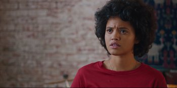 Movie still from “Hearts Beat Loud” (2018), directed by Brett Haley – A young woman with curly black hair wearing a red shirt; Close Up shot, Over the shoulder angle