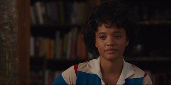 Movie still from “Hearts Beat Loud” (2018), directed by Brett Haley – A young woman with curly black hair wearing a striped shirt; Close Up shot, Over the shoulder angle