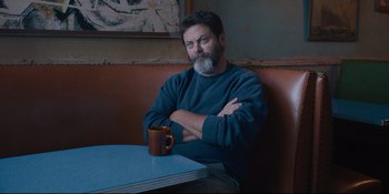 Movie still from “Hearts Beat Loud” (2018), directed by Brett Haley – A man sitting at a table with his arms crossed; Medium shot, Low angle