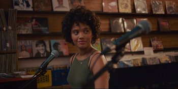 Movie still from “Hearts Beat Loud” (2018), directed by Brett Haley – A woman standing in front of a microphone in a room; Close Up shot, Over the shoulder angle