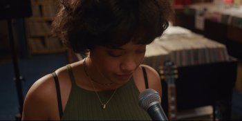 Movie still from “Hearts Beat Loud” (2018), directed by Brett Haley – A woman is holding a microphone in her hand; Close Up shot, Over the shoulder angle