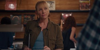 Movie still from “Hearts Beat Loud” (2018), directed by Brett Haley – A woman standing in front of a wall with pictures; Medium shot, Over the shoulder angle