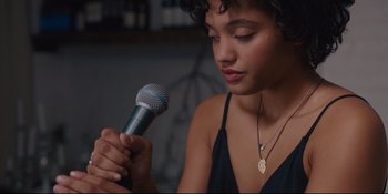 Movie still from “Hearts Beat Loud” (2018), directed by Brett Haley – A woman holding a microphone in front of her face; Close Up shot, Over the shoulder angle
