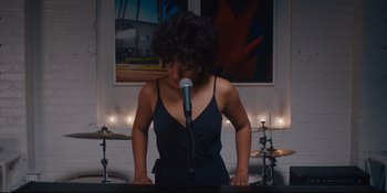 Movie still from “Hearts Beat Loud” (2018), directed by Brett Haley – A woman standing at a microphone in front of a microphone; Medium shot, High angle
