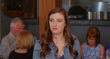 Movie still from “Heaven's Date” (2022), directed by Stevie Fernandez – A woman with long brown hair wearing a jean jacket; Close Up shot, Over the shoulder angle