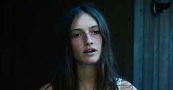 Movie still from “Hellbender” (2021), directed by Zelda Adams – A woman with long black hair and red eyes; Close Up shot, Low angle