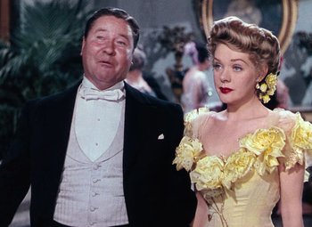 Movie still from “Hello Frisco, Hello” (1943), directed by H. Bruce Humberstone – An older man and a younger woman standing next to each other; Medium shot, Low angle