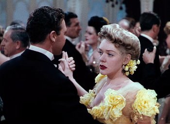 Movie still from “Hello Frisco, Hello” (1943), directed by H. Bruce Humberstone – A man and a woman dancing in formal wear; Medium shot, Over the shoulder angle