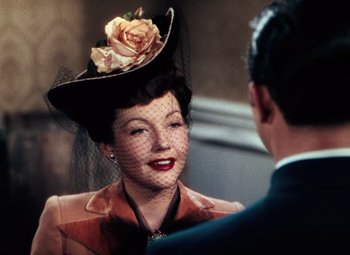 Movie still from “Hello Frisco, Hello” (1943), directed by H. Bruce Humberstone – A woman wearing a hat with a flower on it; Close Up shot, Over the shoulder angle