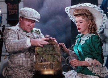 Movie still from “Hello Frisco, Hello” (1943), directed by H. Bruce Humberstone – A man and a woman dressed in period clothing; Medium shot, Low angle