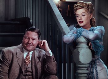 Movie still from “Hello Frisco, Hello” (1943), directed by H. Bruce Humberstone – A man sitting next to a woman on the stairs; Medium shot, Low angle