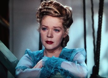 Movie still from “Hello Frisco, Hello” (1943), directed by H. Bruce Humberstone – A woman in a blue dress with her arms crossed; Close Up shot, Low angle