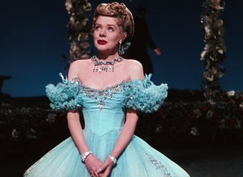 Movie still from “Hello Frisco, Hello” (1943), directed by H. Bruce Humberstone – A woman in a blue dress is standing in front of a stage; Medium shot, Low angle