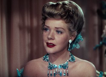 Movie still from “Hello Frisco, Hello” (1943), directed by H. Bruce Humberstone – A woman wearing a necklace and earrings with a butterfly necklace around her neck; Close Up shot, Over the shoulder angle
