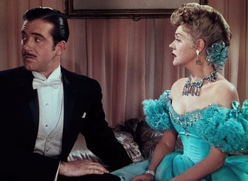 Movie still from “Hello Frisco, Hello” (1943), directed by H. Bruce Humberstone – A man and a woman sitting next to each other in formal wear; Medium shot, Over the shoulder angle