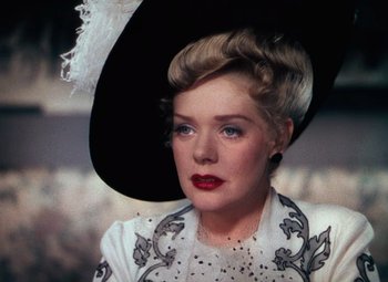 Movie still from “Hello Frisco, Hello” (1943), directed by H. Bruce Humberstone – A woman in a hat and a white dress; Close Up shot, Over the shoulder angle
