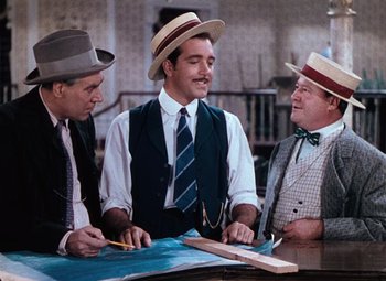 Movie still from “Hello Frisco, Hello” (1943), directed by H. Bruce Humberstone – A group of men sitting at a table with a map; Medium shot, Over the shoulder angle