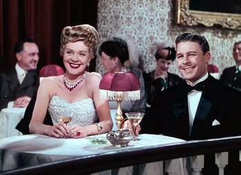 Movie still from “Hello Frisco, Hello” (1943), directed by H. Bruce Humberstone – A man and a woman sitting at a dinner table; Medium shot, Low angle