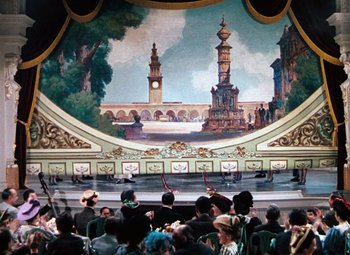 Movie still from “Hello Frisco, Hello” (1943), directed by H. Bruce Humberstone – A group of people sitting in front of a painting; Extreme Wide shot, High angle