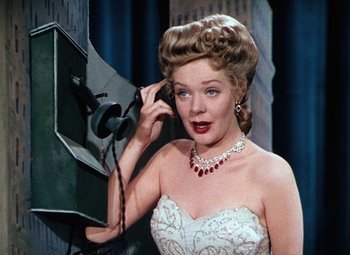 Movie still from “Hello Frisco, Hello” (1943), directed by H. Bruce Humberstone – A woman in a white dress talking on a phone; Close Up shot, Low angle