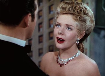 Movie still from “Hello Frisco, Hello” (1943), directed by H. Bruce Humberstone – A woman in a red necklace and a man in a black suit; Close Up shot, Over the shoulder angle