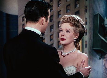 Movie still from “Hello Frisco, Hello” (1943), directed by H. Bruce Humberstone – A man and a woman in formal wear standing next to each other in front of a building; Close Up shot, Over the shoulder angle