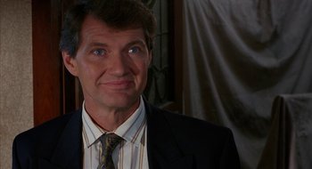 Movie still from “Hellraiser” (1987), directed by Clive Barker – A person wearing a suit and tie; Close Up shot, Low angle