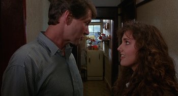 Movie still from “Hellraiser” (1987), directed by Clive Barker – A man and a woman talking to each other in a kitchen; Close Up shot, Over the shoulder angle