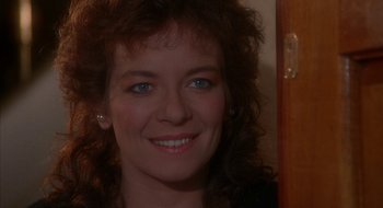 Movie still from “Hellraiser” (1987), directed by Clive Barker – A woman smiling for the camera; Close Up shot, Over the shoulder angle