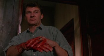 Movie still from “Hellraiser” (1987), directed by Clive Barker – A man holding his hands covered in blood; Close Up shot, Low angle