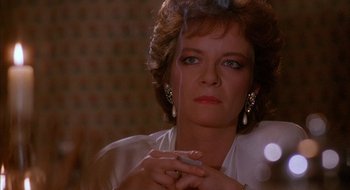 Movie still from “Hellraiser” (1987), directed by Clive Barker – A person smoking a cigarette; Close Up shot, Low angle