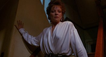 Movie still from “Hellraiser” (1987), directed by Clive Barker – A woman in a white shirt and black belt; Medium shot, Low angle