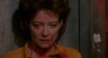 Movie still from “Hellraiser” (1987), directed by Clive Barker – A person with blood all over her face; Close Up shot, Over the shoulder angle