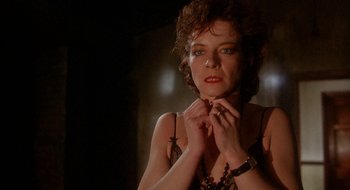 Movie still from “Hellraiser” (1987), directed by Clive Barker – A person holding their hands on their chest; Close Up shot, Low angle