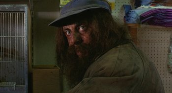 Movie still from “Hellraiser” (1987), directed by Clive Barker – A man with long hair and a beard wearing a hat; Close Up shot, Low angle